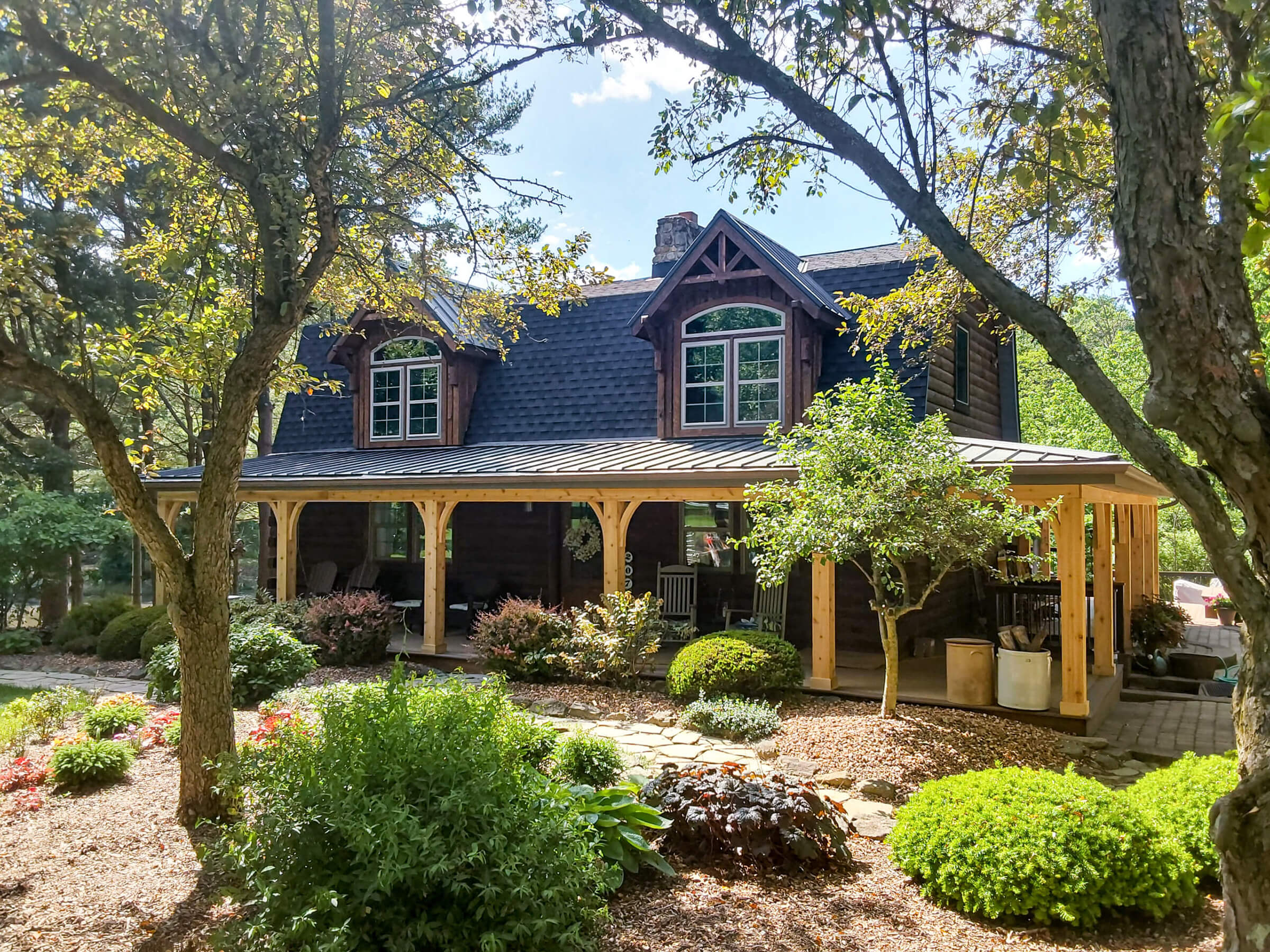 House among trees with a new black shingle roof